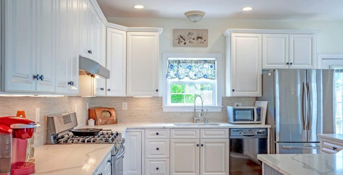 a kitchen with white cabinets and stainless steel appliances